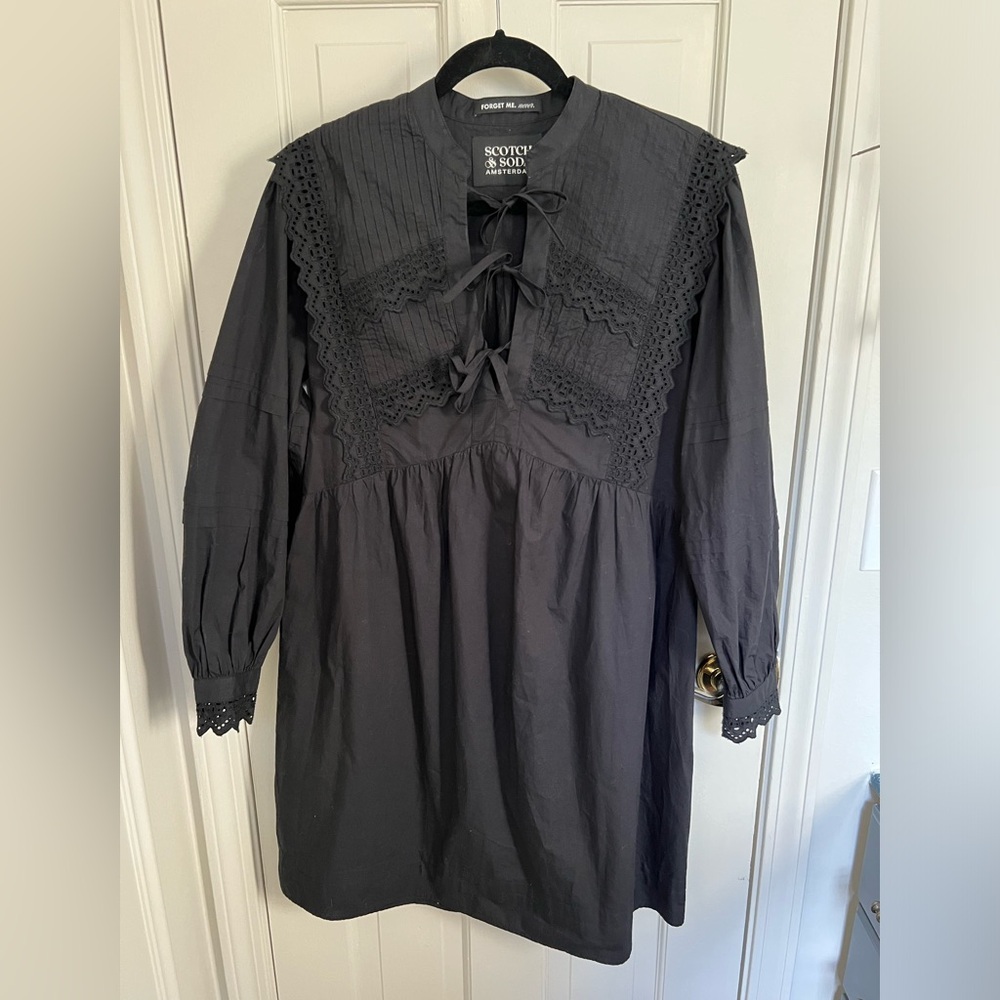 Black eyelet lace dress with bows down the front.